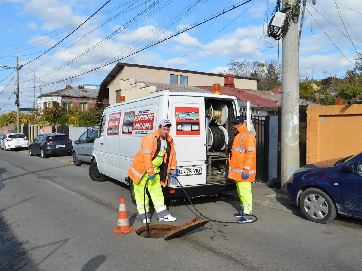 Echipă de desfundare canalizare la un cămin de vizitare, București